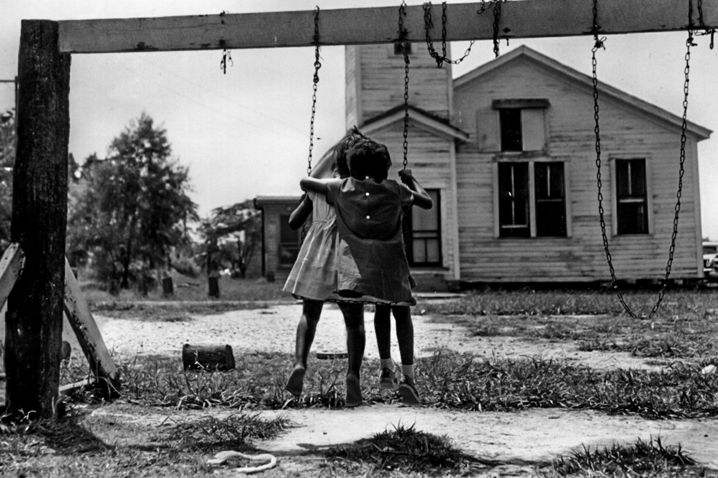 Two black girls sit on a swing at The Child Development Group of Mississippi Head Start in 1965.